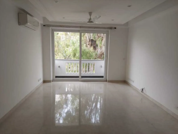 "Spacious, newly renovated apartment room with polished floors and balcony, view of trees, South Delhi rental."