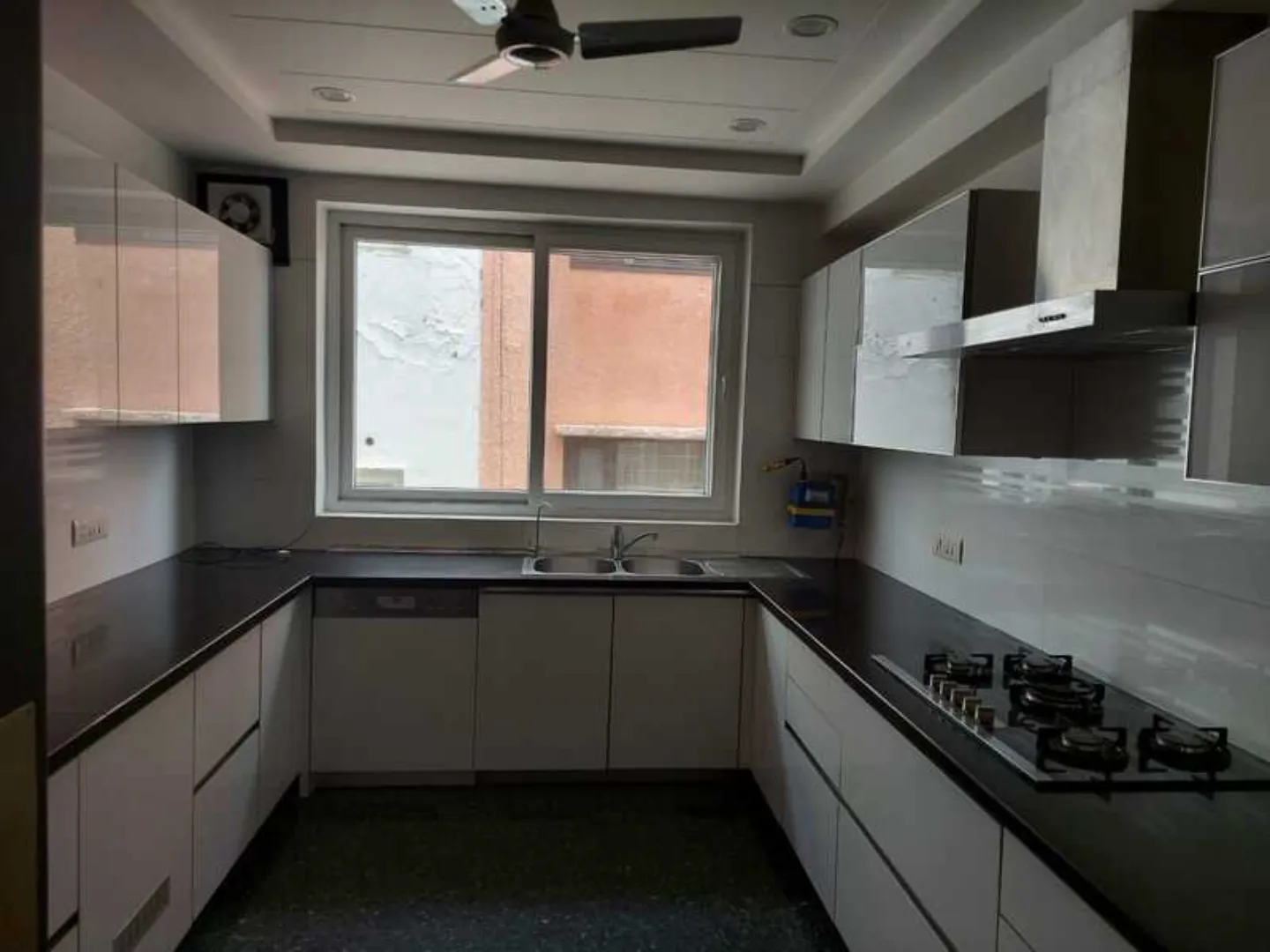 "Sleek kitchen with modular cabinets, gas stove, and dark countertops, South Delhi rental."