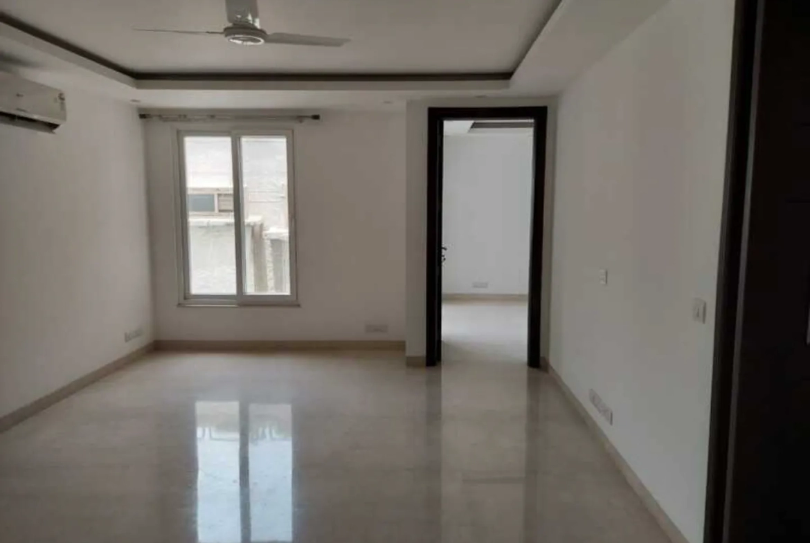 "Modern apartment room with polished floors and open doorway, ready to move, South Delhi."