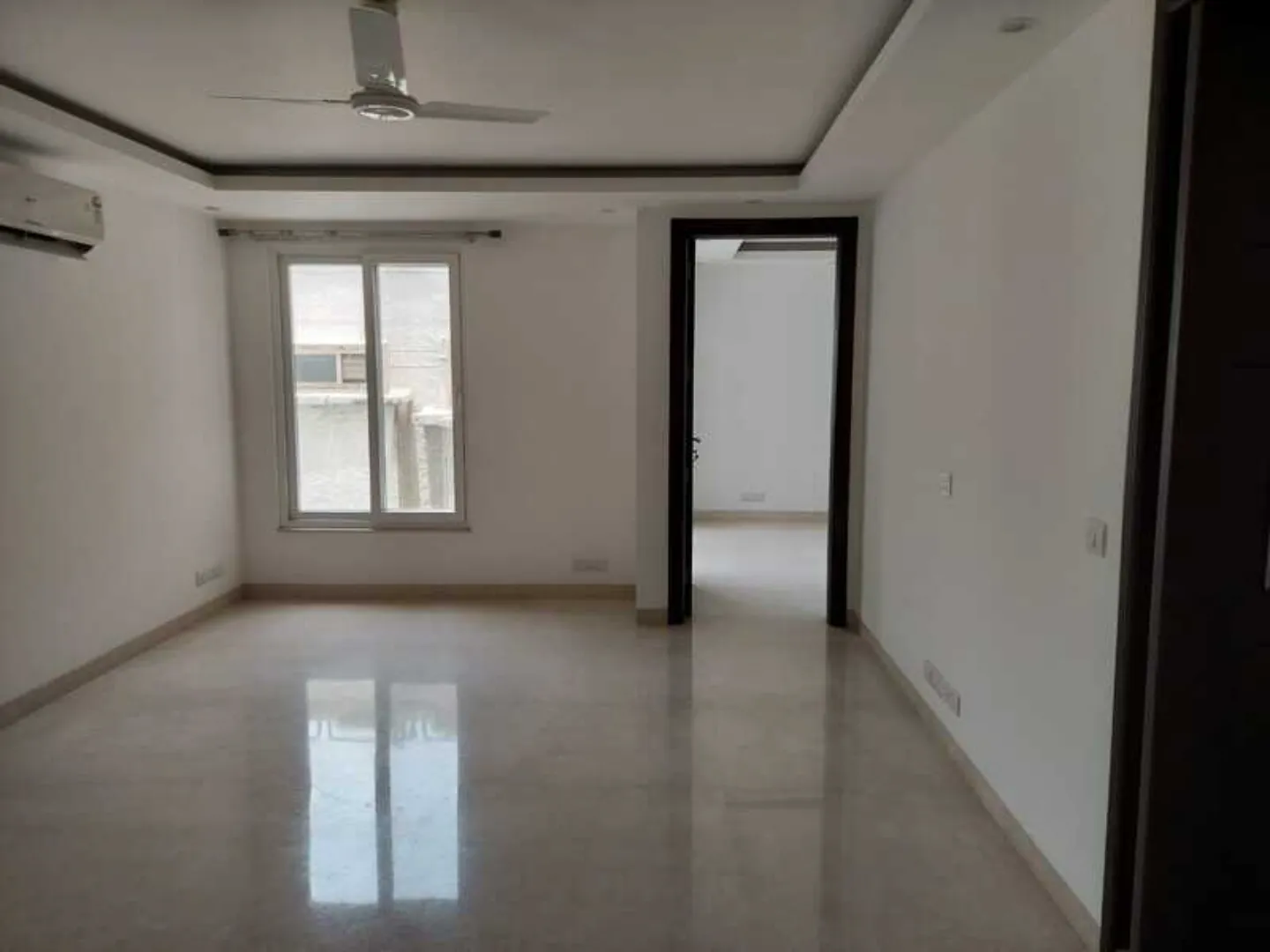 "Modern apartment room with polished floors and open doorway, ready to move, South Delhi."